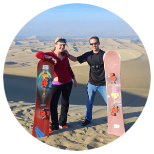 Megan Jerrard and her husband standing with snowboards in Peru to sandboard